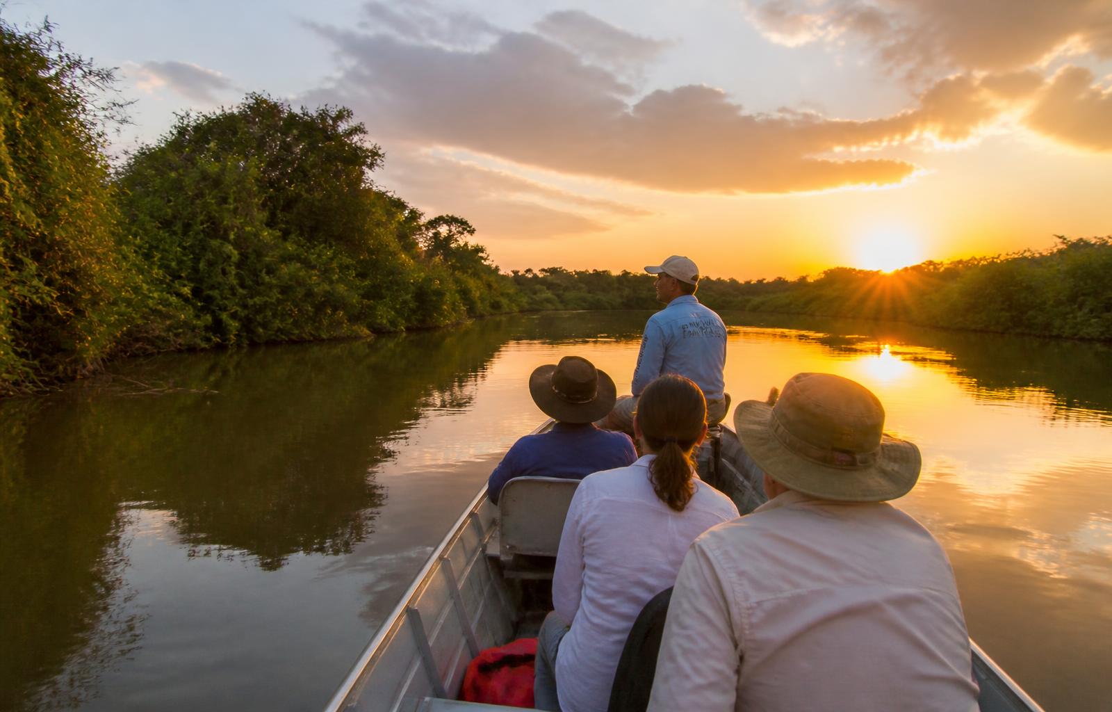 Travelers on a Pantanal river at sunset